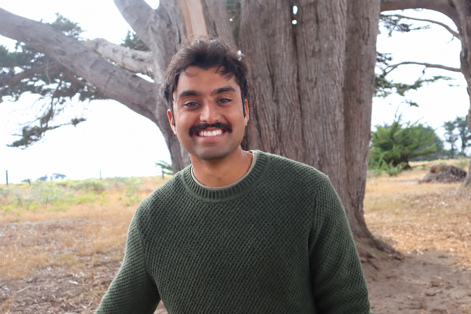 Vivek Hatte smiling outdoors beside a tree